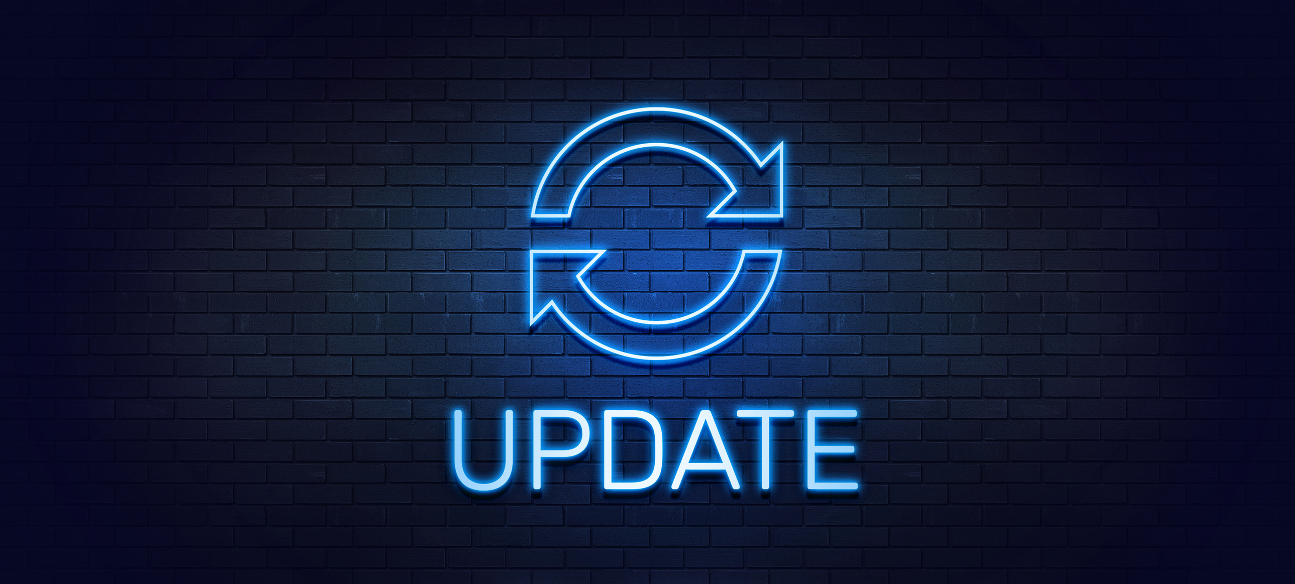 Image of a brick wall with a neon sign with two arrows going in a circle with the word "update" underneath